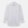 View 2 of product A man wearing the Turnbull & Asser Grey Multi Stripe Regular Fit Twill Shirt with T&A Collar and Double Cuffs stands against a beige background, one hand in his pocket, looking at the camera.