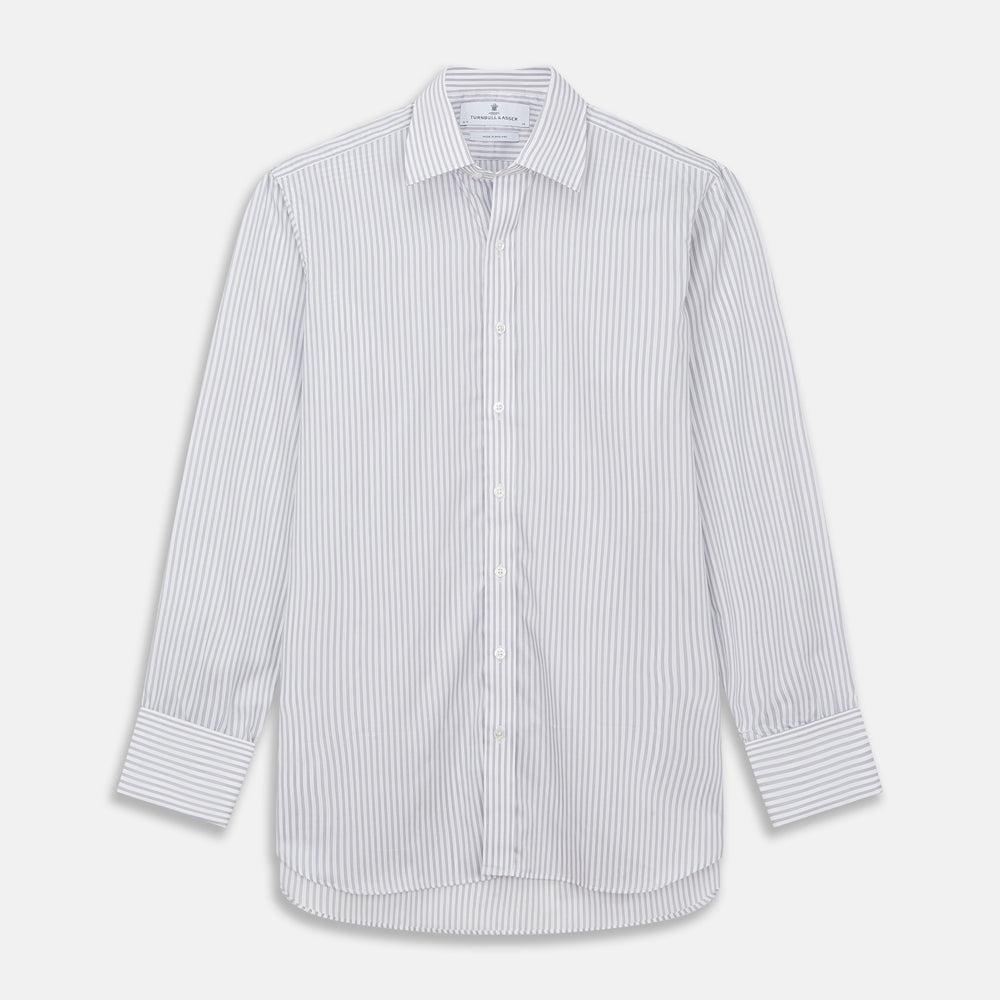 A man wearing the Turnbull & Asser Grey Multi Stripe Regular Fit Twill Shirt with T&A Collar and Double Cuffs stands against a beige background, one hand in his pocket, looking at the camera.