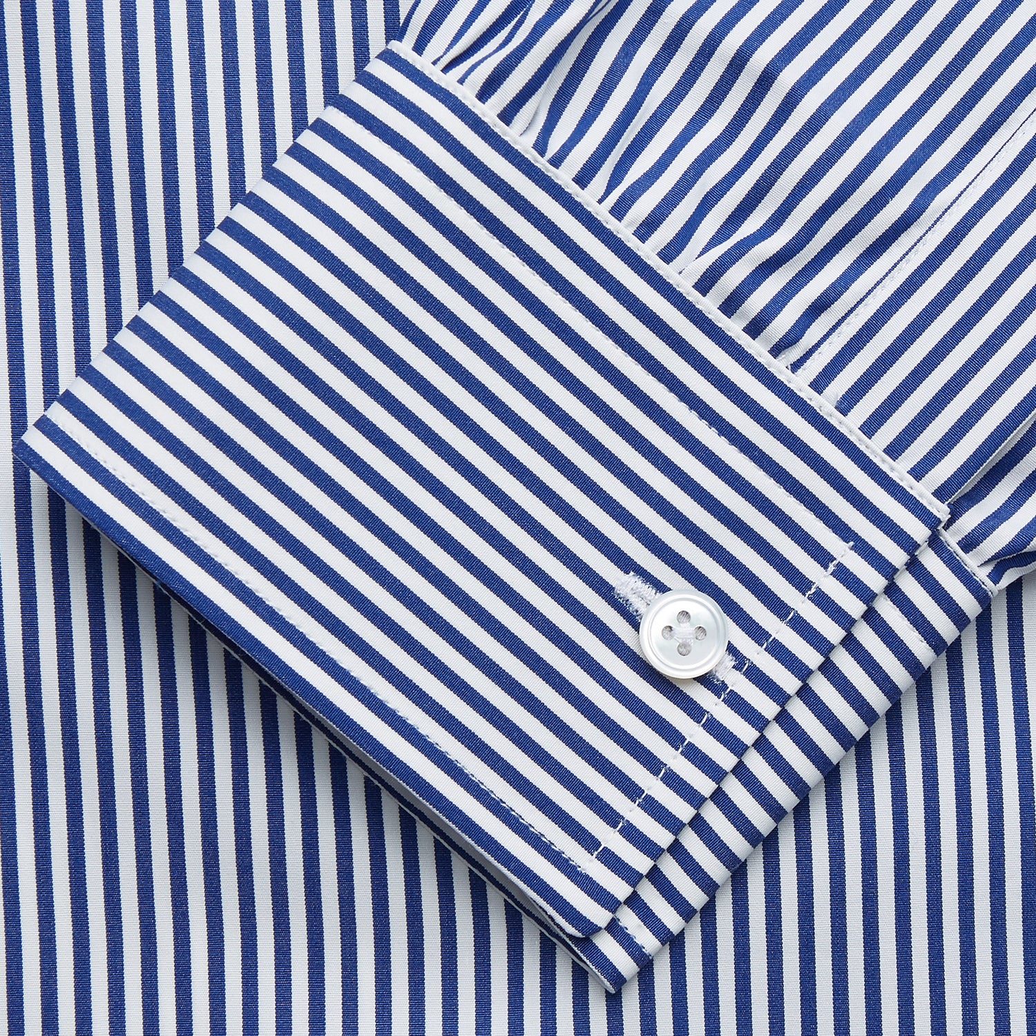View 3 of product The Turnbull & Asser Navy & White Stripe Weekend Fit Shirt features a Derby collar, 1-button cuffs, front chest pocket, vertical stripes, and white buttons. Displayed flat on a white background.