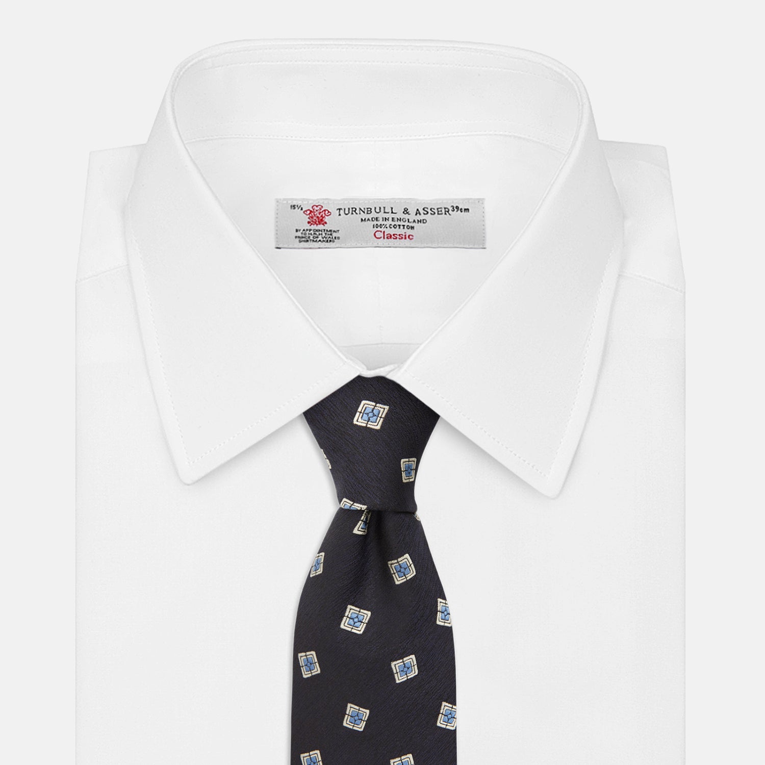 View 2 of product The Turnbull & Asser Navy Multi Geo Silk Tie features a dark navy blue geometric pattern with blue and cream squares—ideal for pairing with bold signature shirts from the autumn-winter collection.