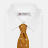 View 2 of product The Orange Multi Neat Silk Tie by Turnbull & Asser, from the autumn-winter collection, features a golden yellow geometric pattern on textured silk. Shown rolled on a white background, it pairs perfectly with bold signature shirts.
