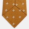 View 4 of product The Orange Multi Neat Silk Tie by Turnbull & Asser, from the autumn-winter collection, features a golden yellow geometric pattern on textured silk. Shown rolled on a white background, it pairs perfectly with bold signature shirts.