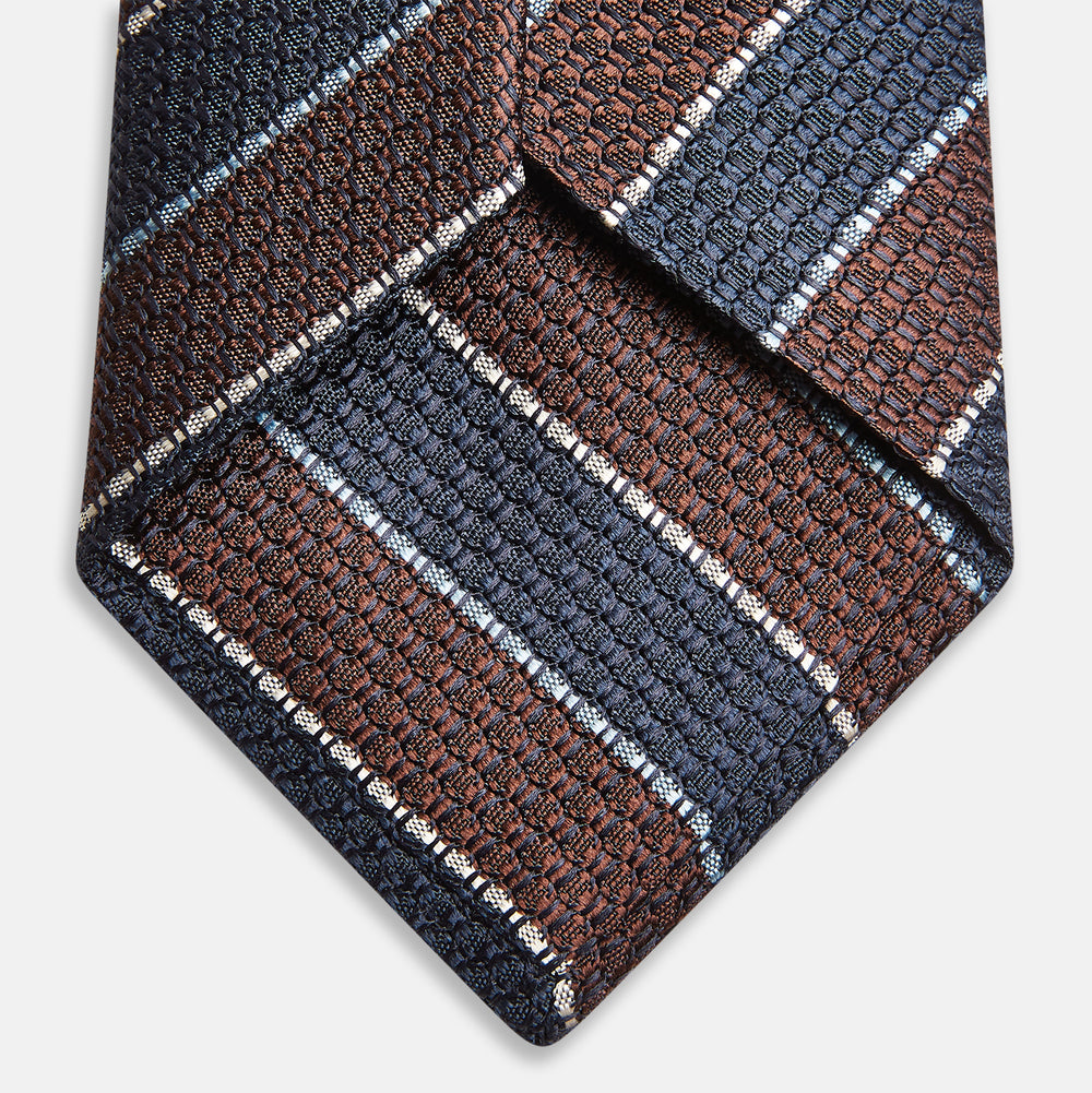 The Turnbull & Asser Burgundy & Navy Multi Stripe Silk Tie features bold stripes and a textured, woven silk design—ideal for adding sophistication to any formal ensemble.