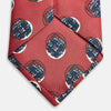 View 6 of product A rolled-up Red Shadow Spot Printed Silk Tie by Turnbull & Asser, showcasing large navy blue and white circular motifs, displayed on a plain white background.