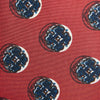 View 5 of product A rolled-up Red Shadow Spot Printed Silk Tie by Turnbull & Asser, showcasing large navy blue and white circular motifs, displayed on a plain white background.