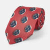 View 1 of product A rolled-up Red Shadow Spot Printed Silk Tie by Turnbull & Asser, showcasing large navy blue and white circular motifs, displayed on a plain white background.