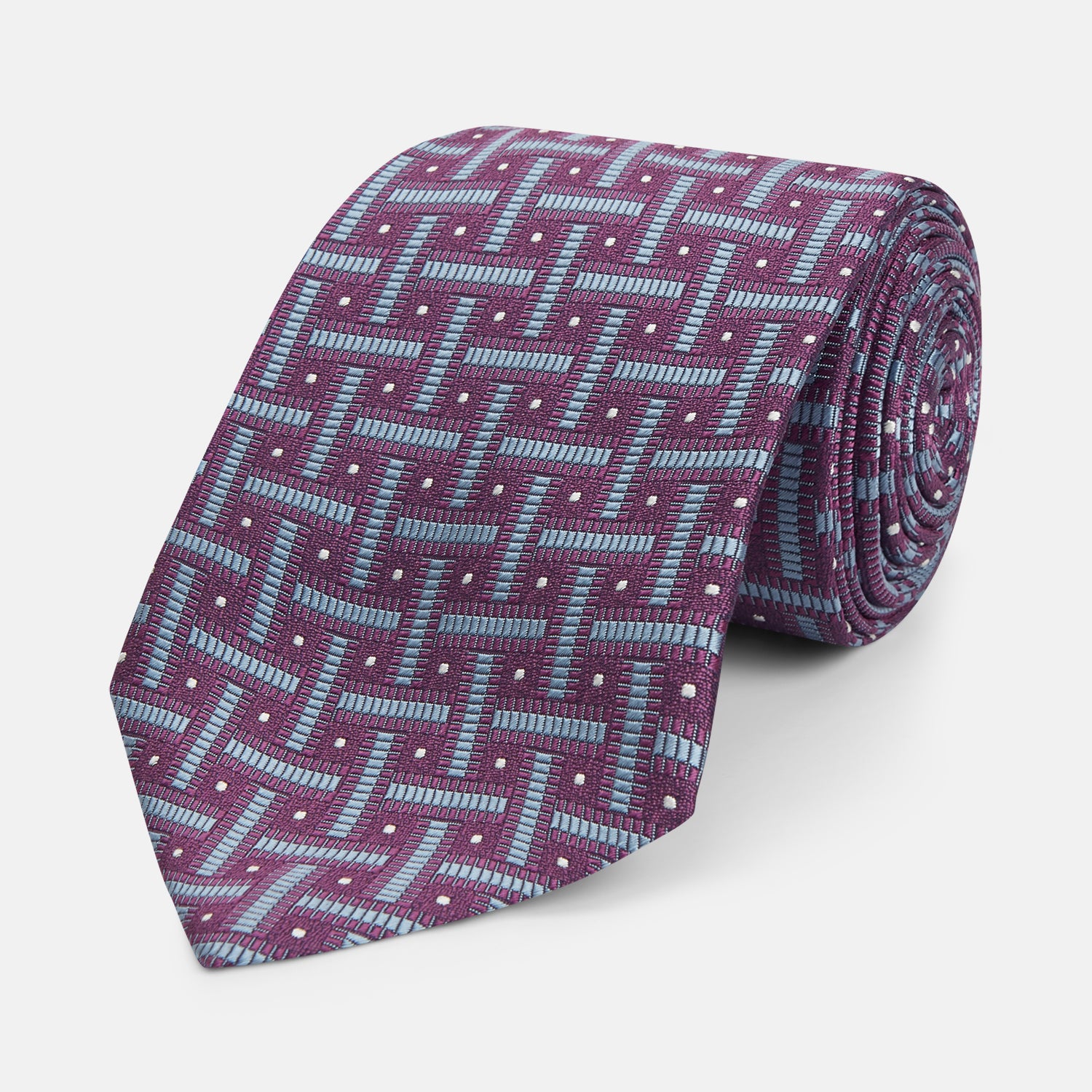 View 1 of product The Turnbull & Asser Purple & Navy Cross Silk Tie features a geometric pattern of intersecting blue lines and white dots—an ideal accessory to elevate formal outfits or complement signature shirts.