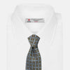 View 2 of product The Turnbull & Asser Green & Navy Cross Silk Tie features an olive green base with navy geometric patterns and white dots, shown rolled on a light surface—an ideal accessory to elevate any formal look.