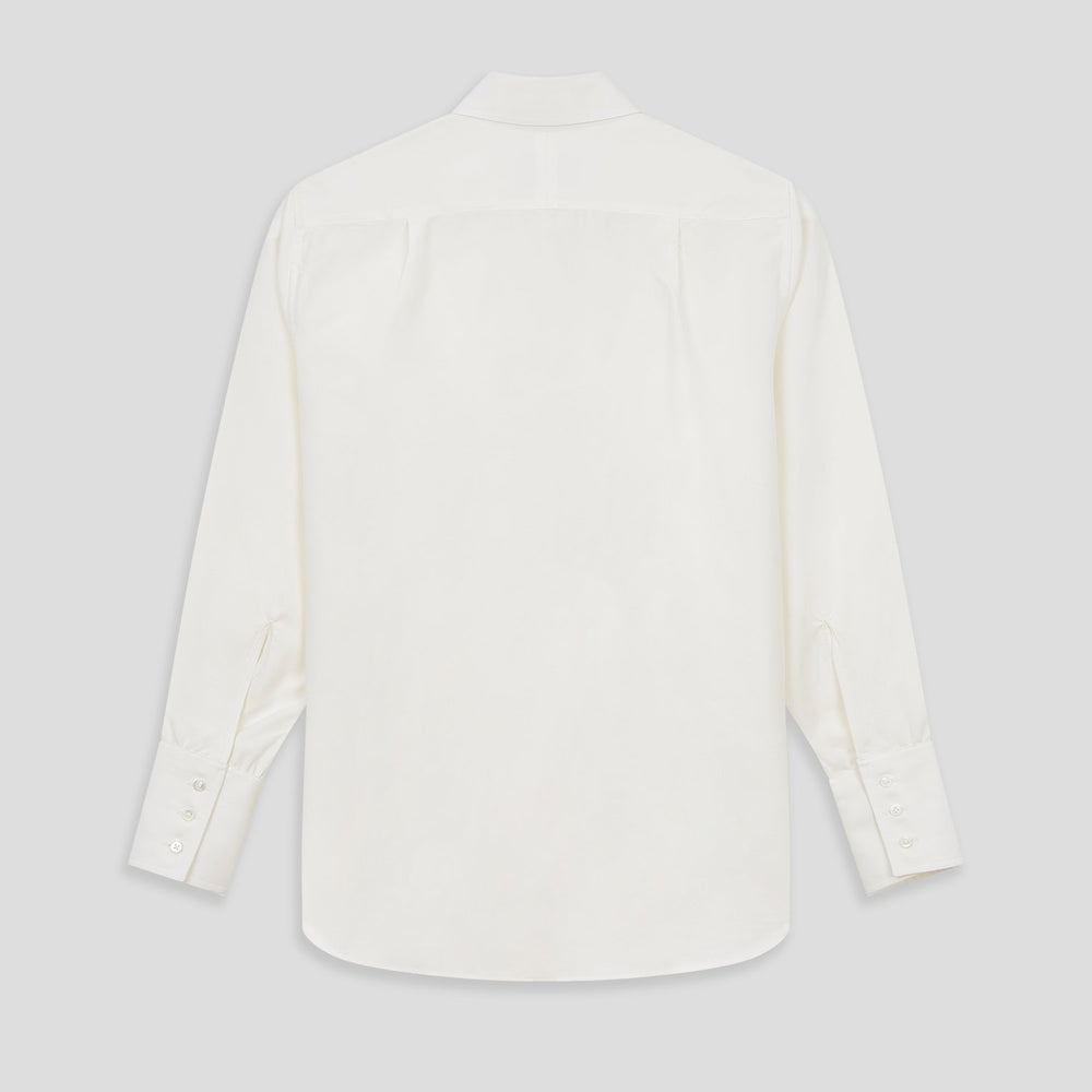 The Turnbull & Asser Turnbull and The Deck Cream Silk Romantic Shirt features long sleeves, a pointed collar, and elegant front ruffles, shown against a plain light gray background.