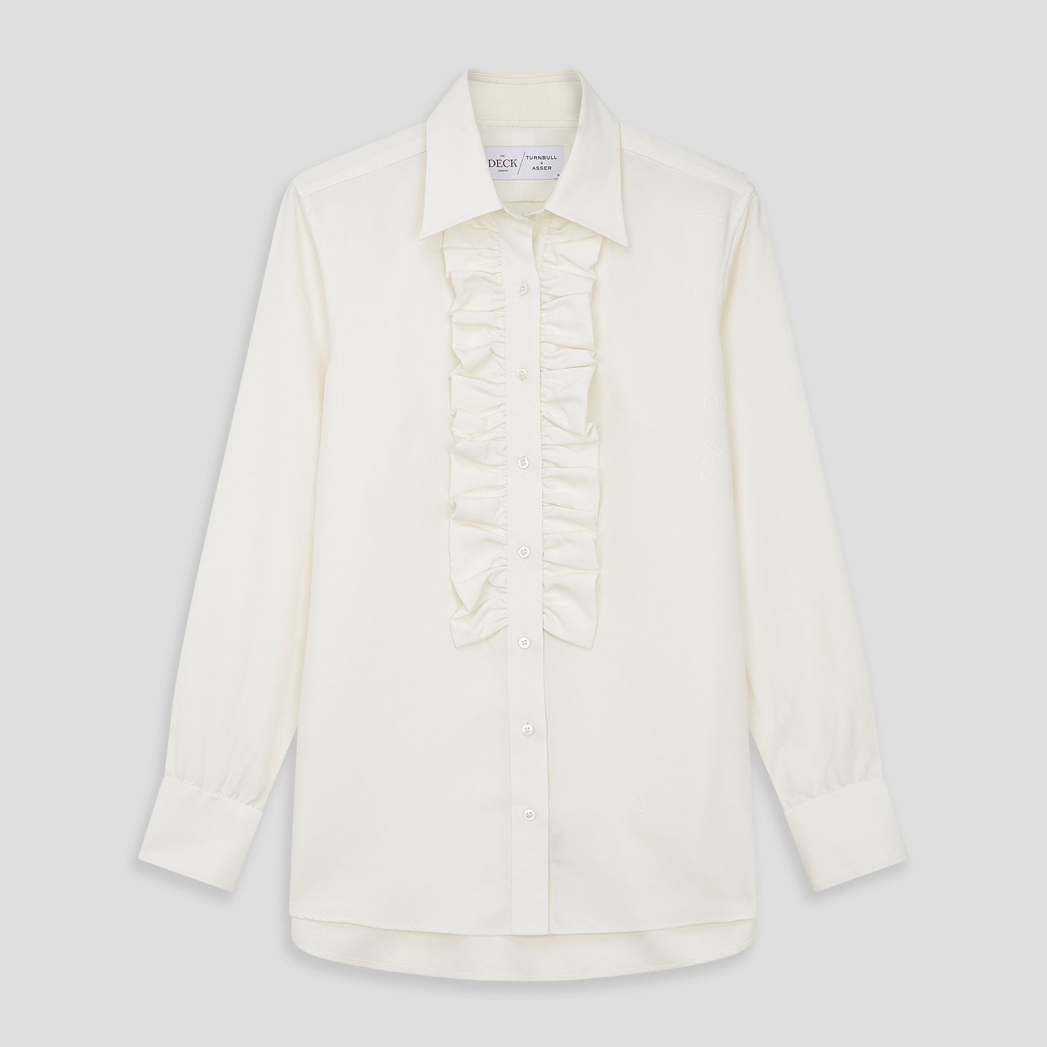 View 1 of product The Turnbull & Asser Turnbull and The Deck Cream Silk Romantic Shirt features long sleeves, a pointed collar, and elegant front ruffles, shown against a plain light gray background.