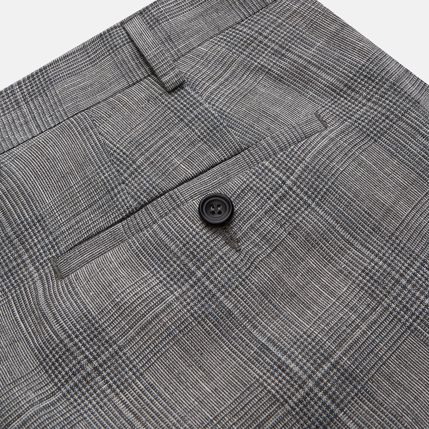 View 2 of product The Turnbull & Asser Grey Multi Check Linen Blend Darlington Trousers, featuring a straight-leg cut, belt loops, front zipper, and pressed center creases, are laid flat on a light gray background.
