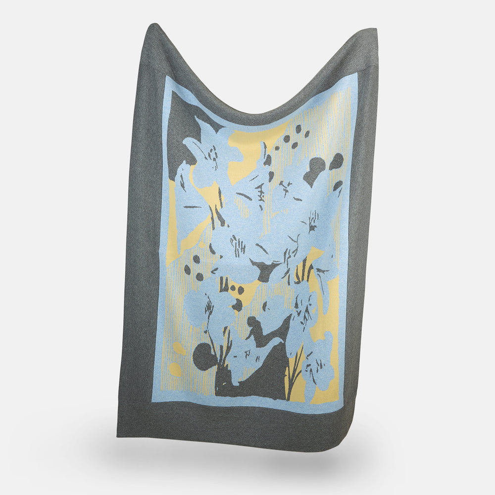 The Pale Blue Wool and Cashmere Lily Blanket by Turnbull & Asser features abstract, hand-drawn designs in blue, yellow, and gray on a white background.