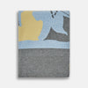 View 1 of product The Pale Blue Wool and Cashmere Lily Blanket by Turnbull & Asser features abstract, hand-drawn designs in blue, yellow, and gray on a white background.