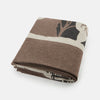 View 7 of product The Grey Wool And Cashmere Lily Blanket by Turnbull & Asser features an abstract animal outline in brown, beige, and dark grey on white. Expertly hand-finished, this folded blanket blends wool and cashmere for a luxurious touch.