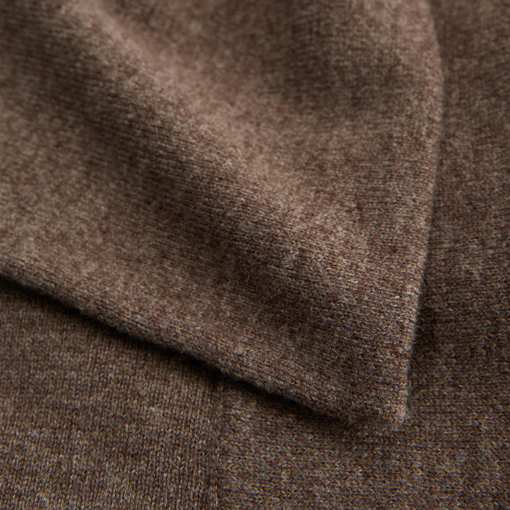 The Grey Wool And Cashmere Lily Blanket by Turnbull & Asser features an abstract animal outline in brown, beige, and dark grey on white. Expertly hand-finished, this folded blanket blends wool and cashmere for a luxurious touch.