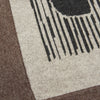 View 4 of product The Grey Wool And Cashmere Lily Blanket by Turnbull & Asser features an abstract animal outline in brown, beige, and dark grey on white. Expertly hand-finished, this folded blanket blends wool and cashmere for a luxurious touch.