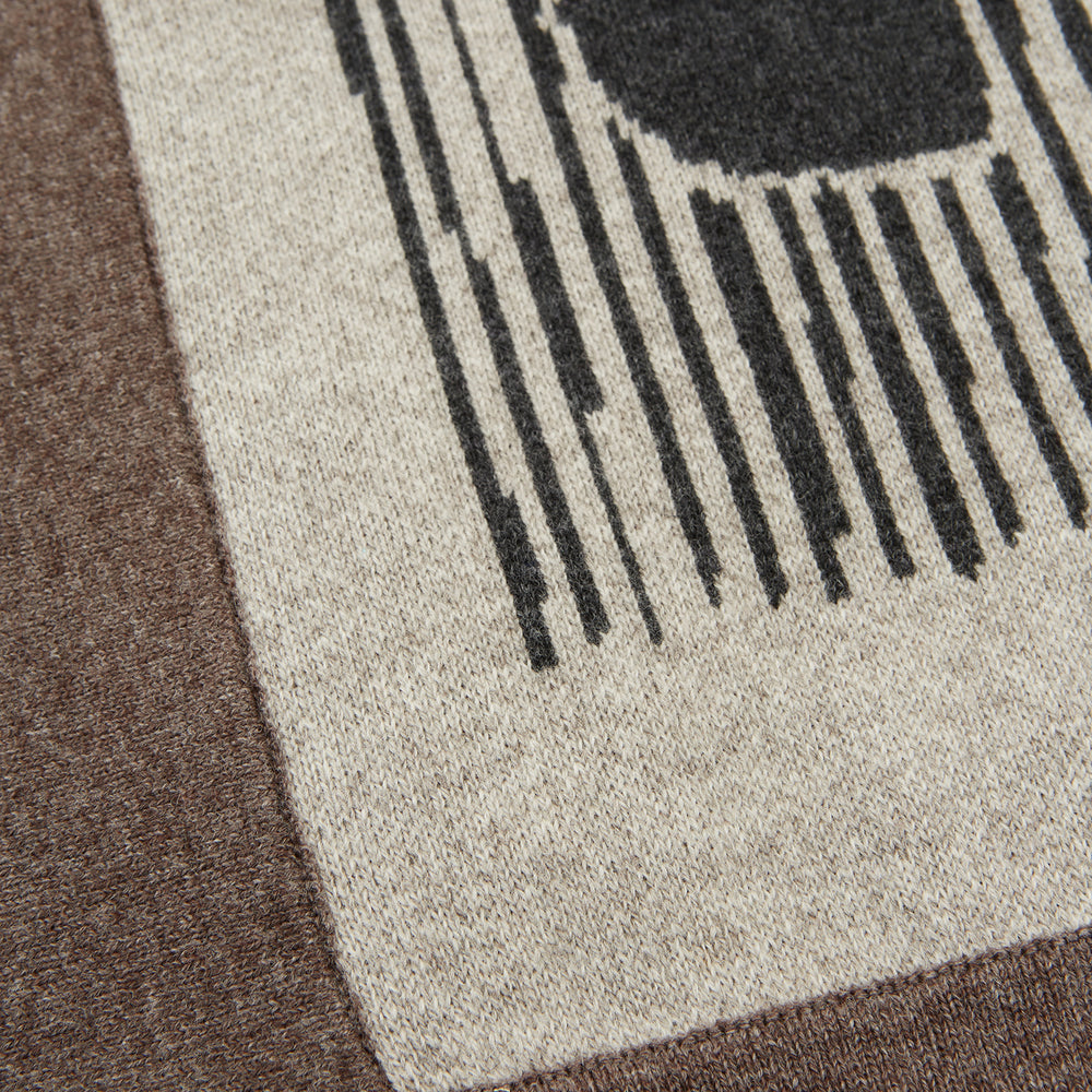 The Grey Wool And Cashmere Lily Blanket by Turnbull & Asser features an abstract animal outline in brown, beige, and dark grey on white. Expertly hand-finished, this folded blanket blends wool and cashmere for a luxurious touch.