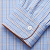 View 2 of product The Turnbull & Asser Pale Blue Multi Check Cotton Sussex Nightshirt features a classic plaid pattern, brown piping accents, button-down front, chest pocket, and curved hem—a timeless long-sleeve sleepwear essential.