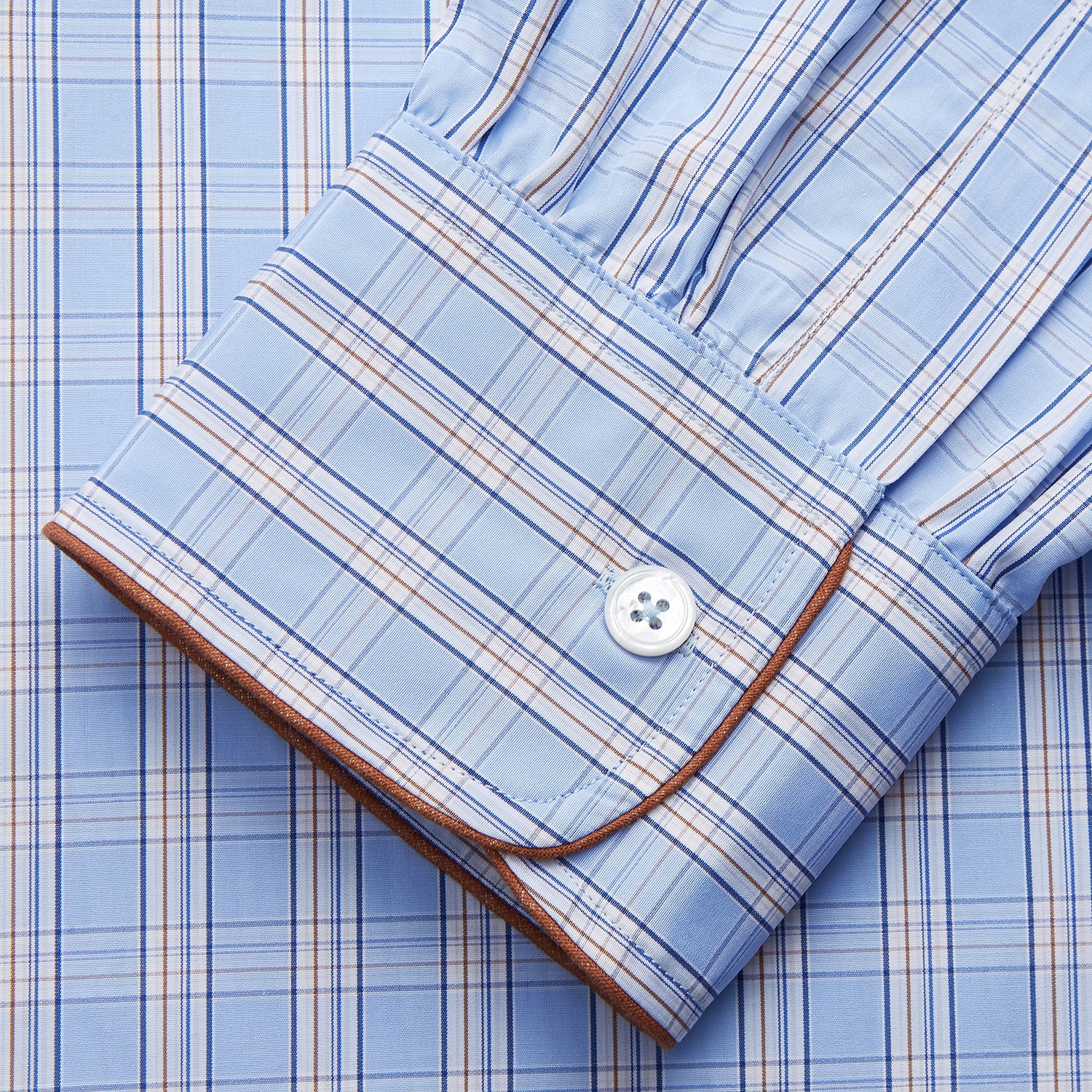 View 2 of product The Turnbull & Asser Pale Blue Multi Check Cotton Sussex Nightshirt features a classic plaid pattern, brown piping accents, button-down front, chest pocket, and curved hem—a timeless long-sleeve sleepwear essential.
