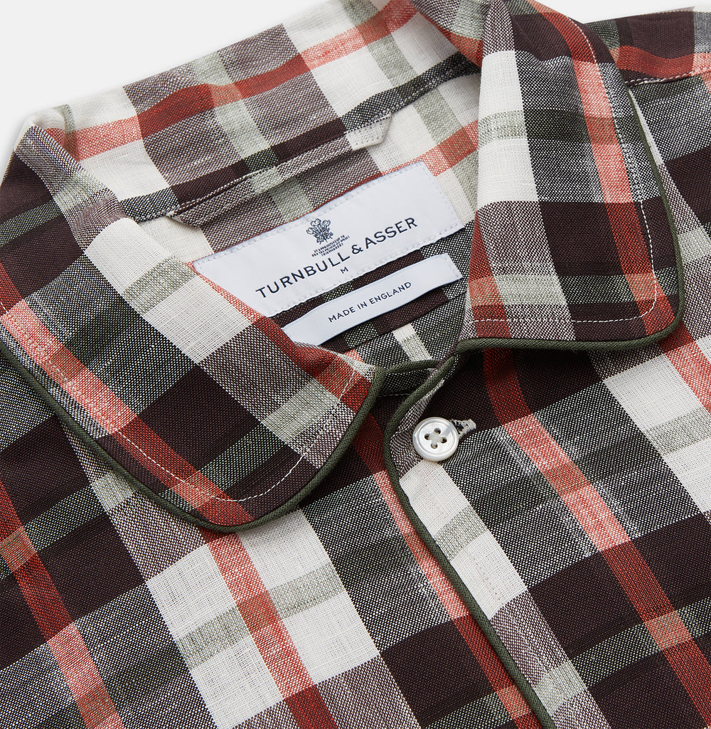 The Black Multi Check Linen Blend Sussex Nightshirt by Turnbull & Asser features a red, black, and white check pattern, button-down front, chest pocket, curved hemline, and brings a luxurious touch to classic sleepwear style.