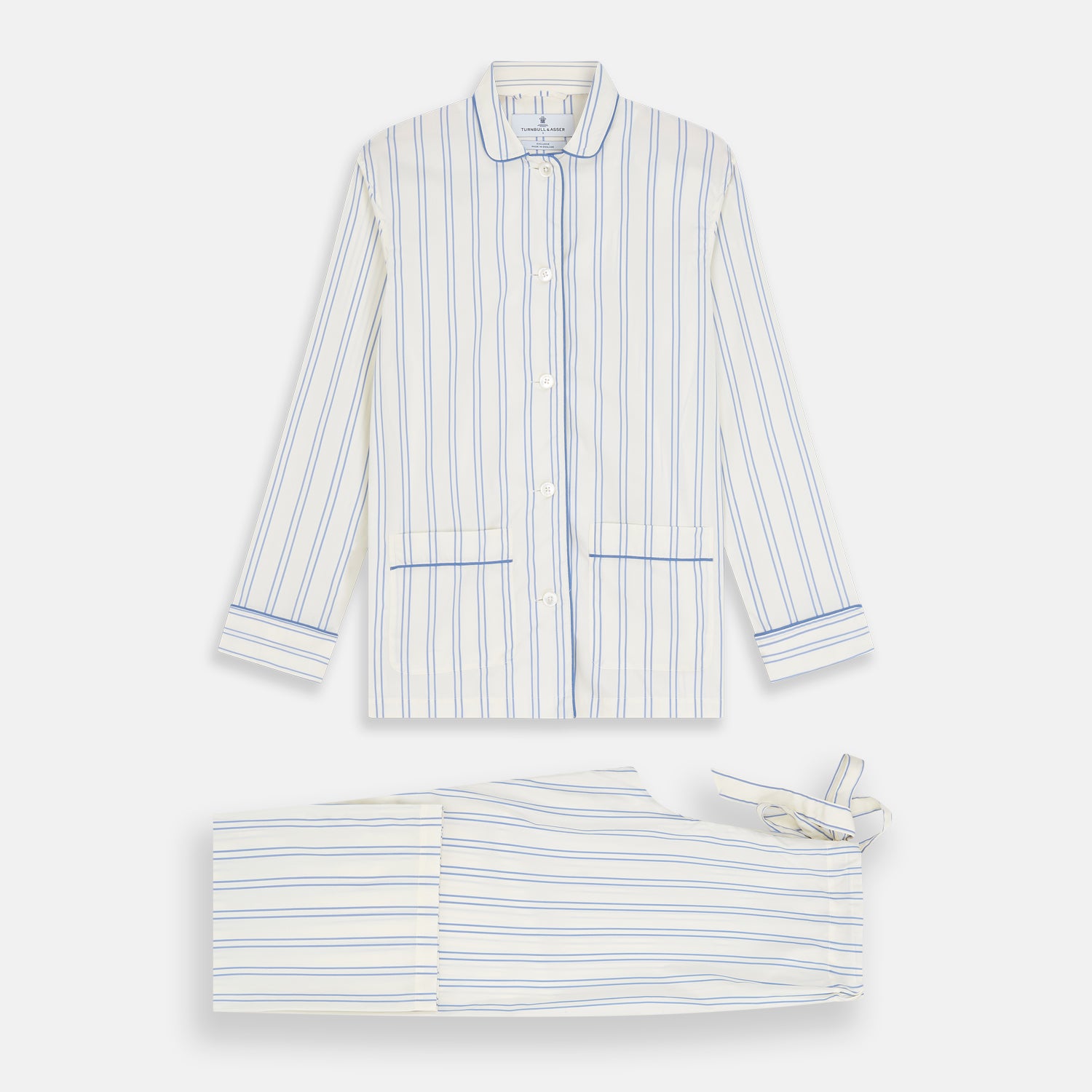 View 5 of product The Turnbull & Asser Women's Blue Multi Cotton Thelma Pyjama Set features a long-sleeve button-up shirt with collar and pocket, plus matching drawstring pants, elegantly displayed against a white background.