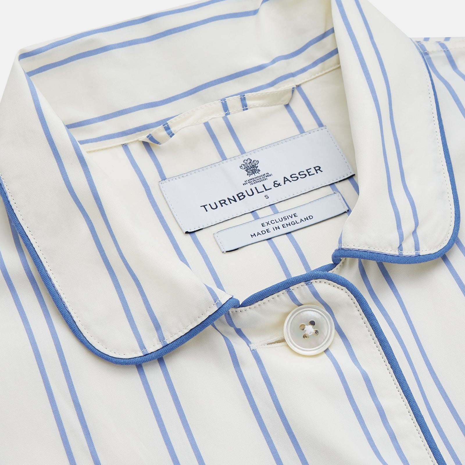View 2 of product The Turnbull & Asser Women's Blue Multi Cotton Thelma Pyjama Set features a long-sleeve button-up shirt with collar and pocket, plus matching drawstring pants, elegantly displayed against a white background.