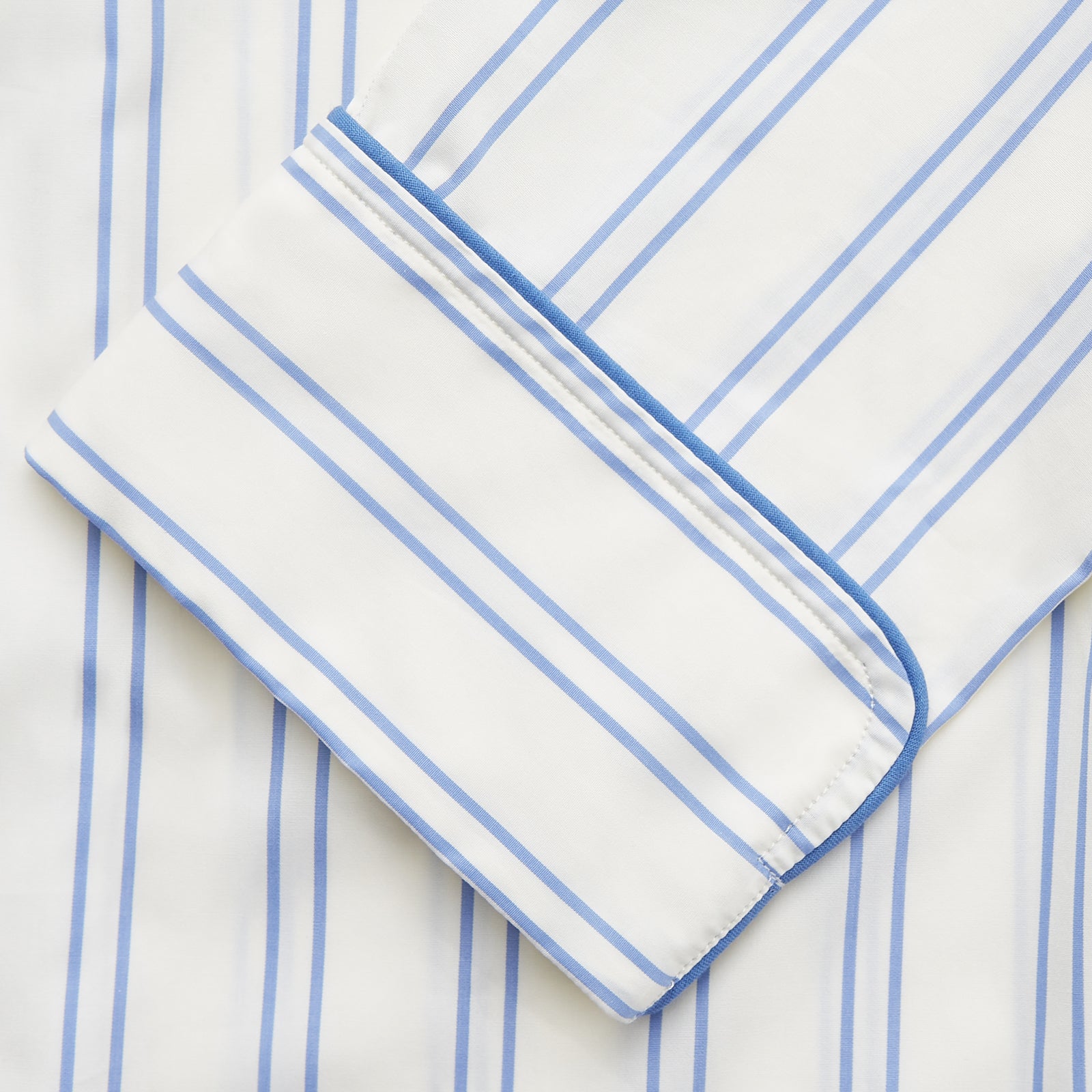 View 3 of product The Turnbull & Asser Women's Blue Multi Cotton Thelma Pyjama Set features a long-sleeve button-up shirt with collar and pocket, plus matching drawstring pants, elegantly displayed against a white background.