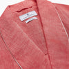 View 4 of product The Pink Linen Arnold Gown by Turnbull & Asser features white piping, long sleeves, a shawl collar, chest pocket, and a wrap-around belt tied at the waist, shown on a white background.
