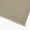 View 2 of product The Khaki Silk Twill Lawton Scarf by Turnbull & Asser, an essential accessory, features fringed edges and is neatly folded on a white background. A small logo near one end adds a refined Turnbull touch.