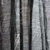 View 5 of product The Turnbull & Asser Black Sketched Pattern Wool Chilcott Scarf features white abstract lines, frayed edges, and is shown loosely knotted on a light gray background.