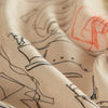 View 4 of product The Turnbull & Asser Cream Sketched Pattern Wool Chilcott Scarf features a lightweight, beige design with frayed edges and multicolored, line-drawn clothing and accessories, shown neatly tied on a plain white background.