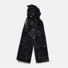 View 1 of product The Turnbull & Asser Black Sketched Pattern Wool Chilcott Scarf features white abstract lines, frayed edges, and is shown loosely knotted on a light gray background.
