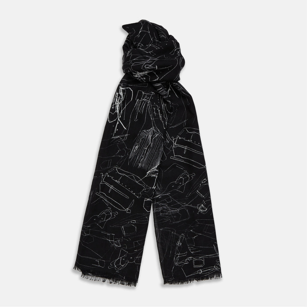 The Turnbull & Asser Black Sketched Pattern Wool Chilcott Scarf features white abstract lines, frayed edges, and is shown loosely knotted on a light gray background.