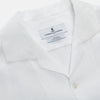 View 3 of product The Turnbull & Asser White Linen Holiday Fit Winnington Shirt, a long-sleeve style with a revere collar and chest pocket, is shown laid flat on a white background.