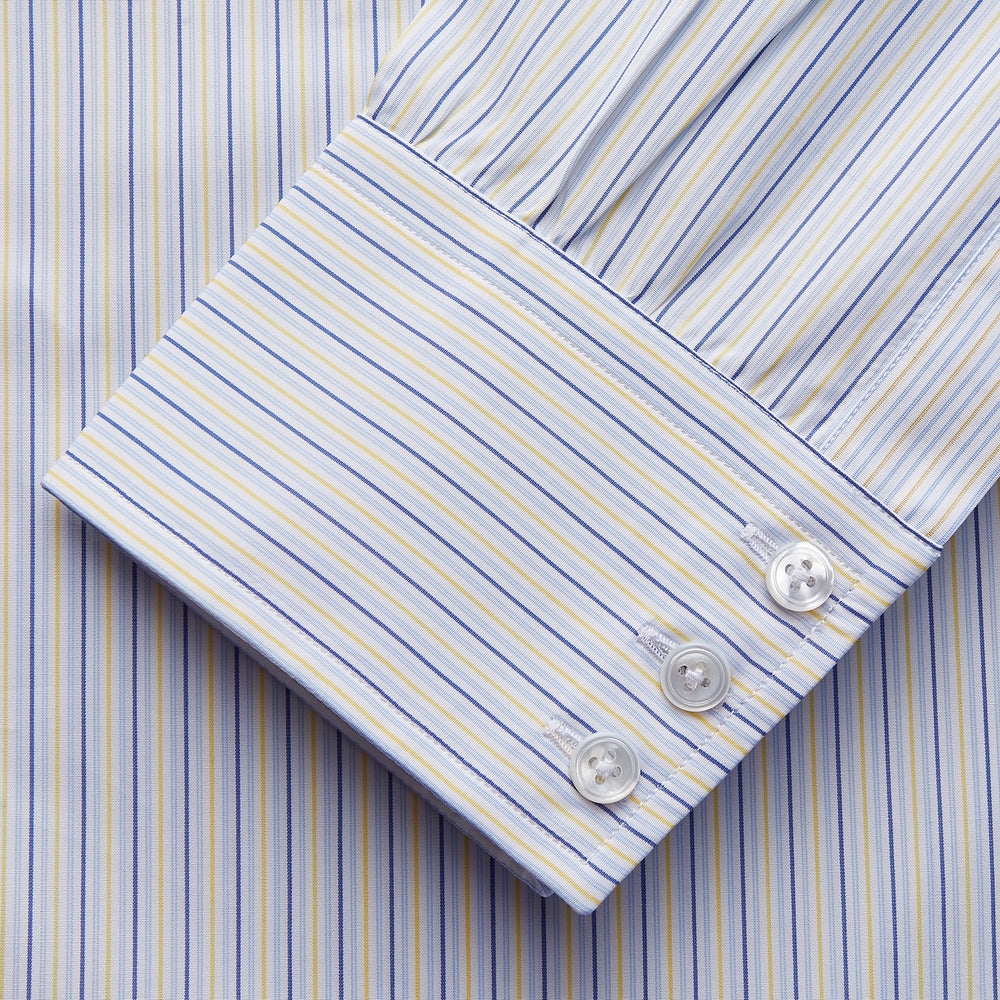 The Light Blue and Yellow Stripe Cotton RE-PURPOSE Mayfair Shirt by Turnbull & Asser features long sleeves, a classic collar, buttoned cuffs, a curved hem, and is made from recycled cotton for sustainable style.