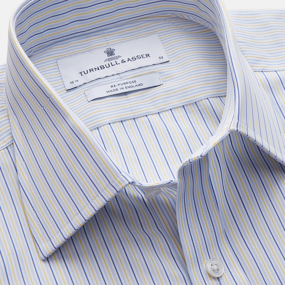 The Light Blue and Yellow Stripe Cotton RE-PURPOSE Mayfair Shirt by Turnbull & Asser features long sleeves, a classic collar, buttoned cuffs, a curved hem, and is made from recycled cotton for sustainable style.