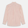View 6 of product A man poses against a beige backdrop in the Turnbull & Asser Red and Off-White Stripe Cotton Weekend Fit Finch Shirt, styled with dark blue jeans and a brown belt for a timeless look. One hand rests in his pocket as he faces slightly to the side.