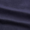 View 5 of product A man stands against a tan background, wearing the Turnbull & Asser Navy Wool Blend Weekend Fit Hayne Shirt tucked into gray dress pants with a black belt and shoes. He has short hair, a neutral expression, and his hands are in his pockets for a casual look.