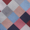 View 3 of product The Turnbull & Asser Pink and Blue Checkerboard Silk Tie is shown rolled up, highlighting its pink, blue, grey, and white pattern against a plain white background.