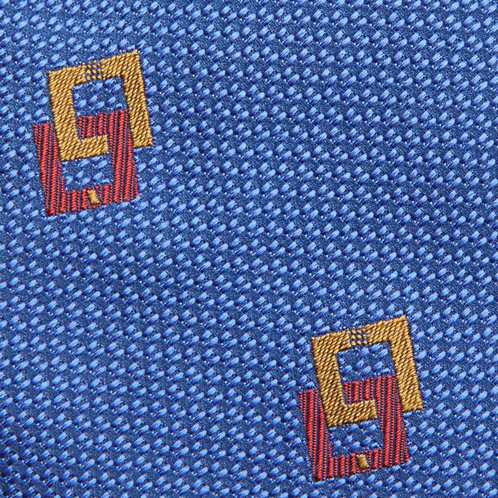 The Blue Geometric Squares Silk Tie by Turnbull & Asser features a classic blue base with small yellow and red geometric shapes, making it a sophisticated textured silk accessory.