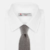 View 2 of product The Grey Multi Cashmere Knitted Tie by Turnbull & Asser features a textured checkered pattern, rolled and displayed on a white background—a refined menswear essential.