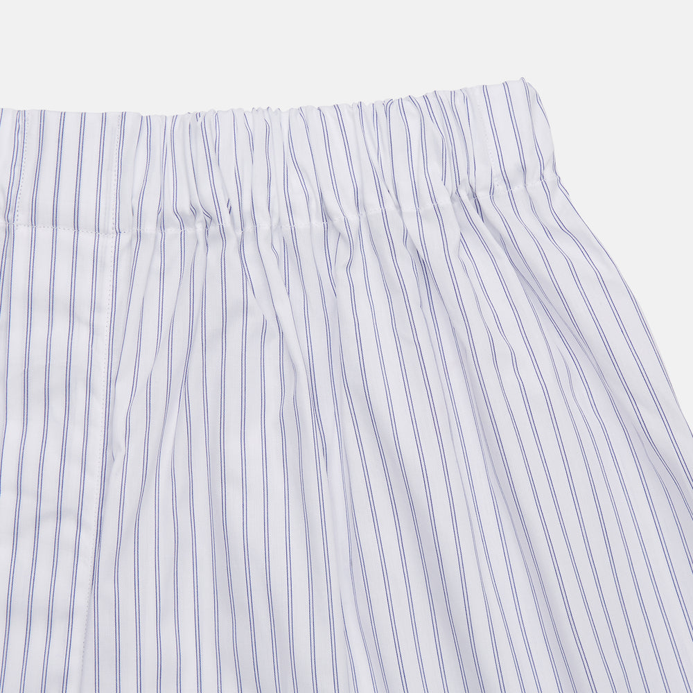 Turnbull & Asser's White and Blue Halo Stripe Cotton Godfrey Boxer Shorts feature thin vertical blue stripes, an elastic waistband, and offer comfortable sleepwear. The shorts are shown laid flat on a plain white background.