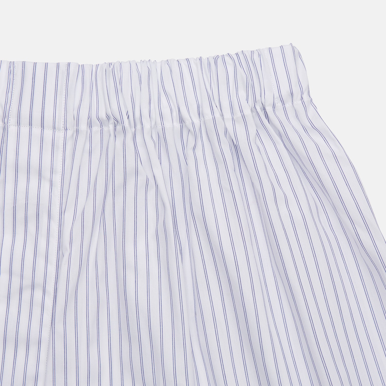 View 2 of product Turnbull & Asser's White and Blue Halo Stripe Cotton Godfrey Boxer Shorts feature thin vertical blue stripes, an elastic waistband, and offer comfortable sleepwear. The shorts are shown laid flat on a plain white background.