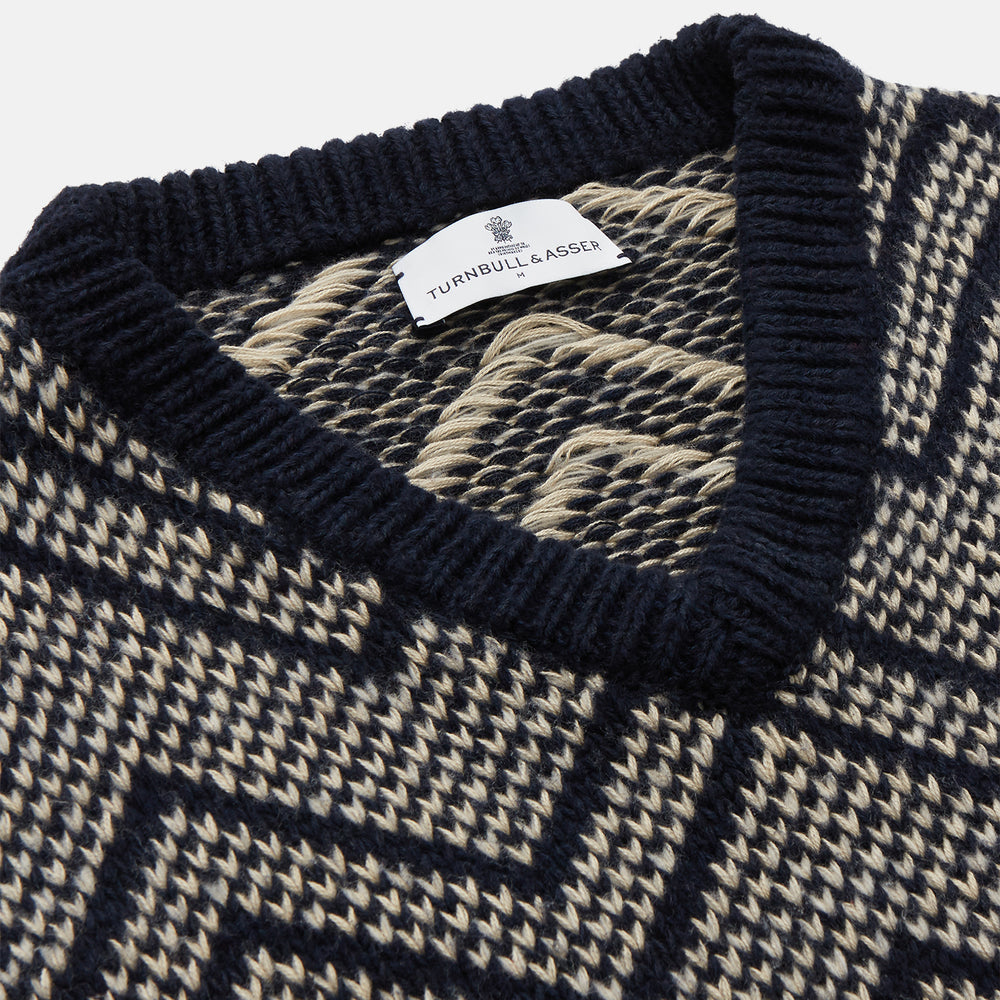 The Turnbull & Asser Navy and White Wool Blend Albion Chunky Slipover is a sleeveless knitted vest with ribbed V-neck, armholes, and hem, featuring a bold chevron pattern.