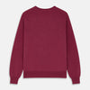 View 3 of product The Turnbull & Asser Soft Burgundy Cashmere V-neck Paden Jumper is displayed flat on a white background, showing off its soft texture and subtle ribbed cuffs and hem.