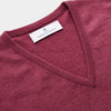 View 2 of product The Turnbull & Asser Soft Burgundy Cashmere V-neck Paden Jumper is displayed flat on a white background, showing off its soft texture and subtle ribbed cuffs and hem.