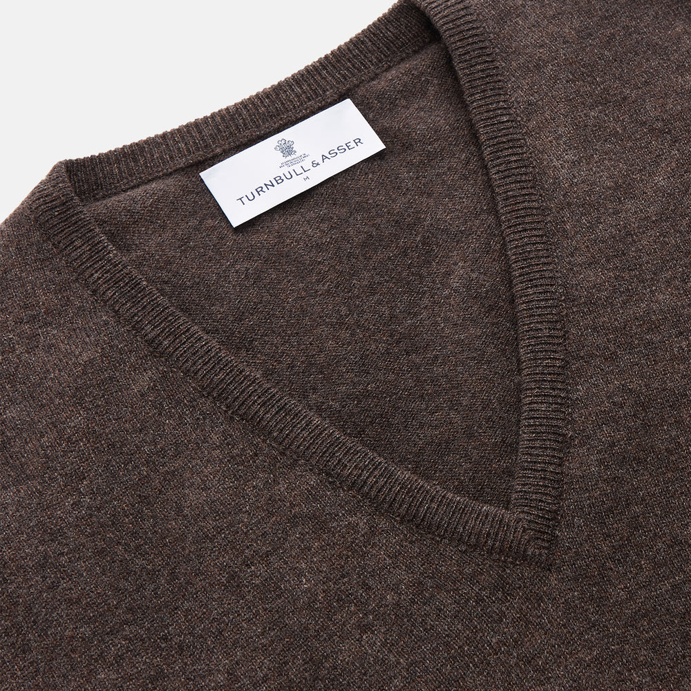 The Brown Cashmere V-neck Paden Jumper by Turnbull & Asser is laid flat on a white background, showcasing its classic design with long sleeves, ribbed cuffs, and hem—perfect for versatile styling.