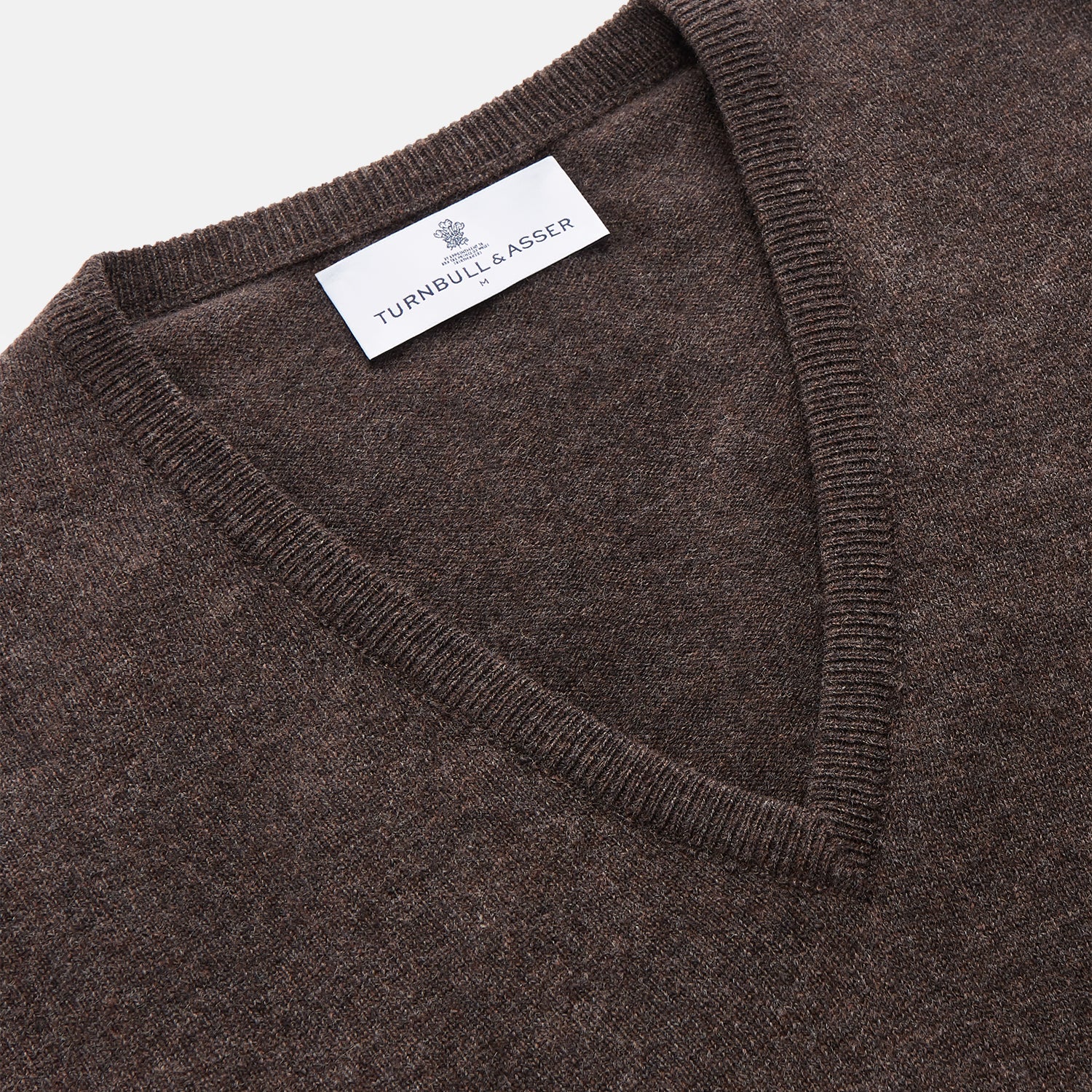 View 2 of product The Brown Cashmere V-neck Paden Jumper by Turnbull & Asser is laid flat on a white background, showcasing its classic design with long sleeves, ribbed cuffs, and hem—perfect for versatile styling.