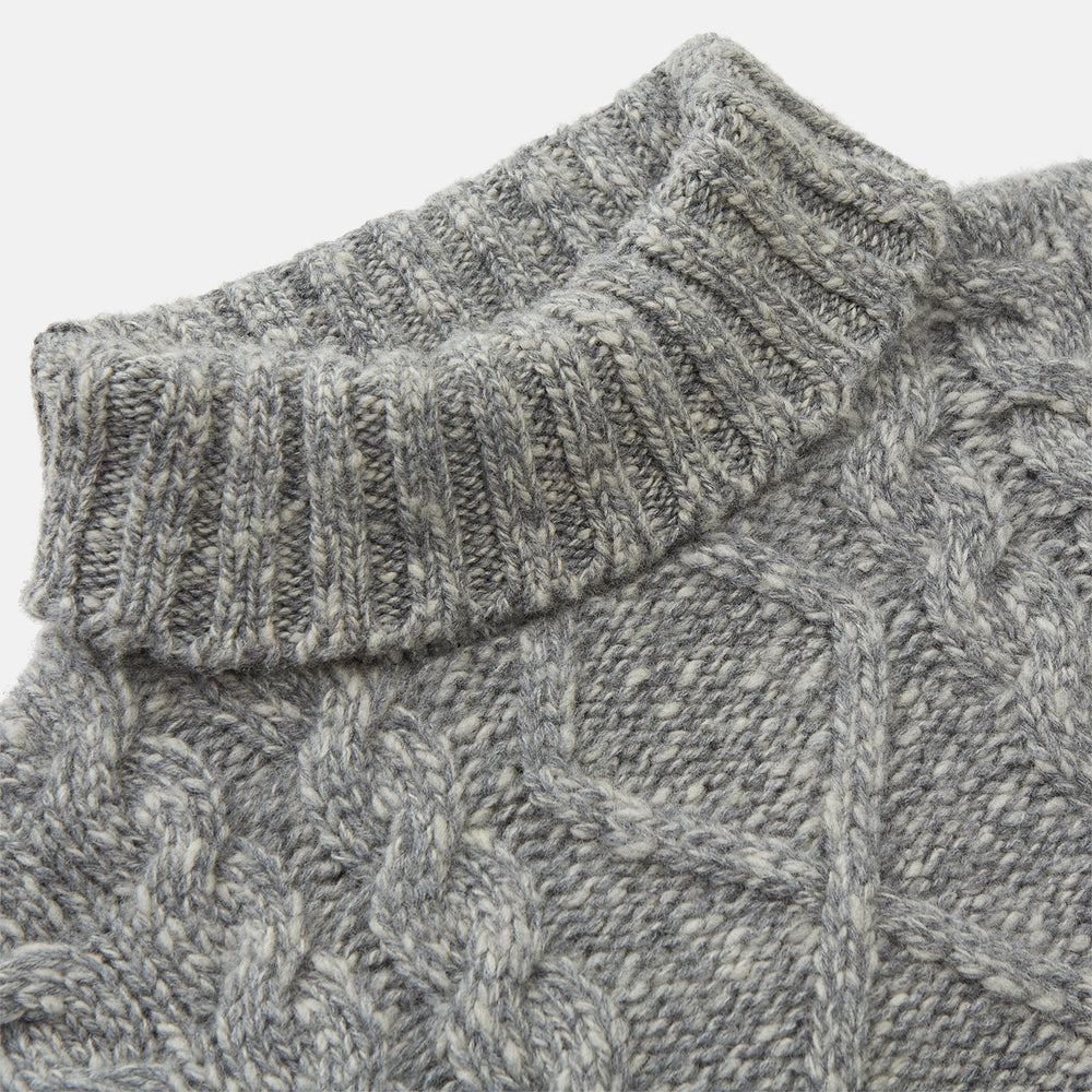 The Oatmeal Cashmere Melange Clark Roll Neck Jumper by Turnbull & Asser features a high roll-neck, long sleeves, and a textured cable knit front, crafted from a soft cashmere blend.