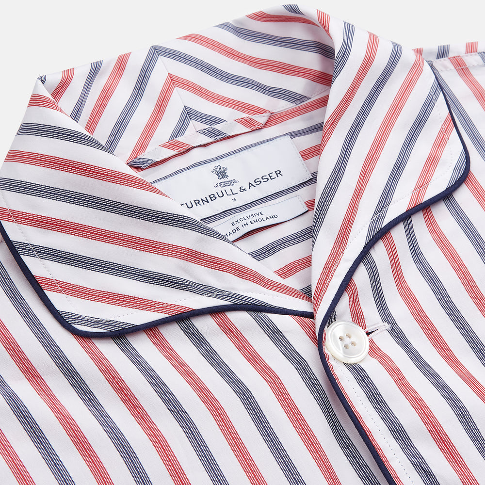 The Turnbull & Asser Red and Blue Stripe Cotton Quin Pyjamas feature a collared, long-sleeve button-up top with black piping and chest pocket, paired with matching striped pants for luxurious comfort and style.